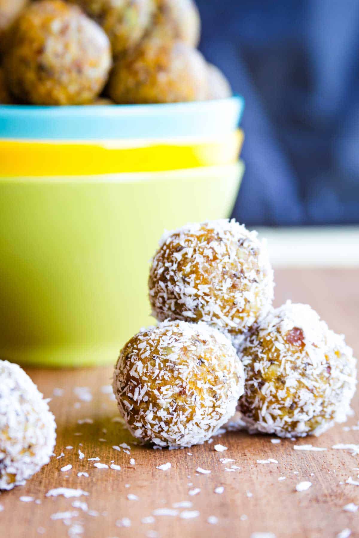 Coconut-covered apricot energy balls in a pyramid stack.