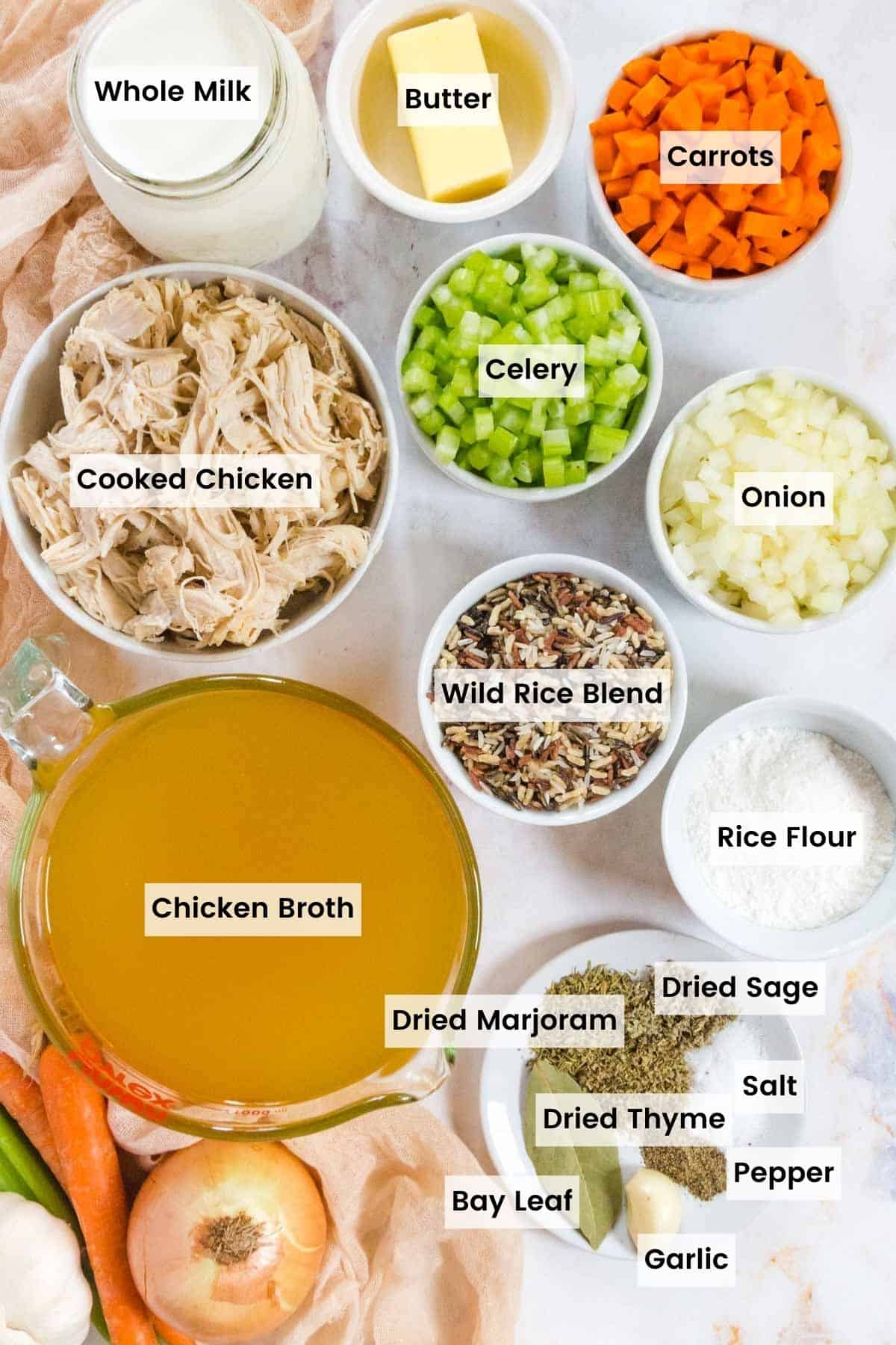 Bowls and containers of the ingredients to make this chicken wild rice soup recipe with text labels.