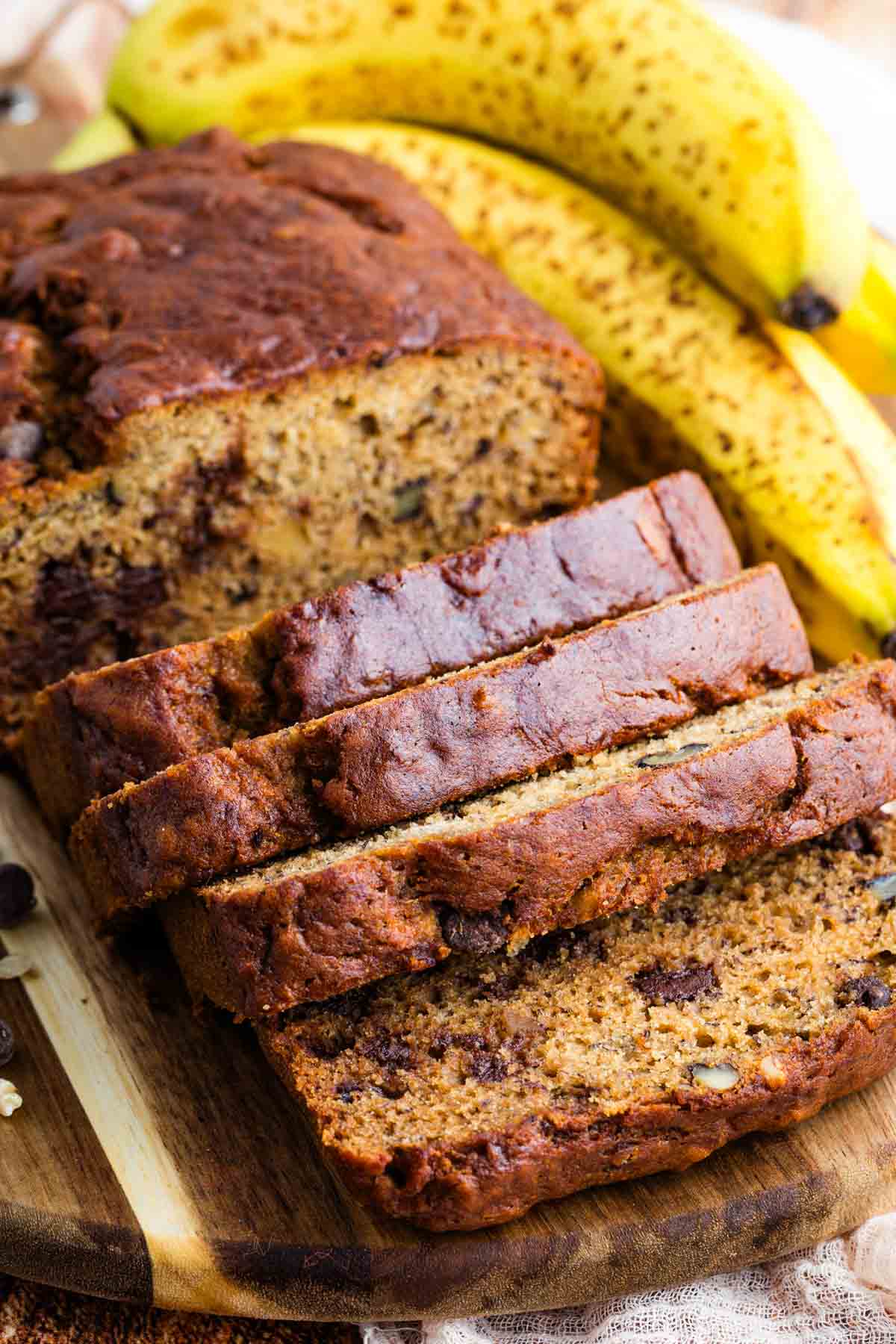 Overhead view of a slice loaf of gluten free chocolate chip banana bread on a cutting board