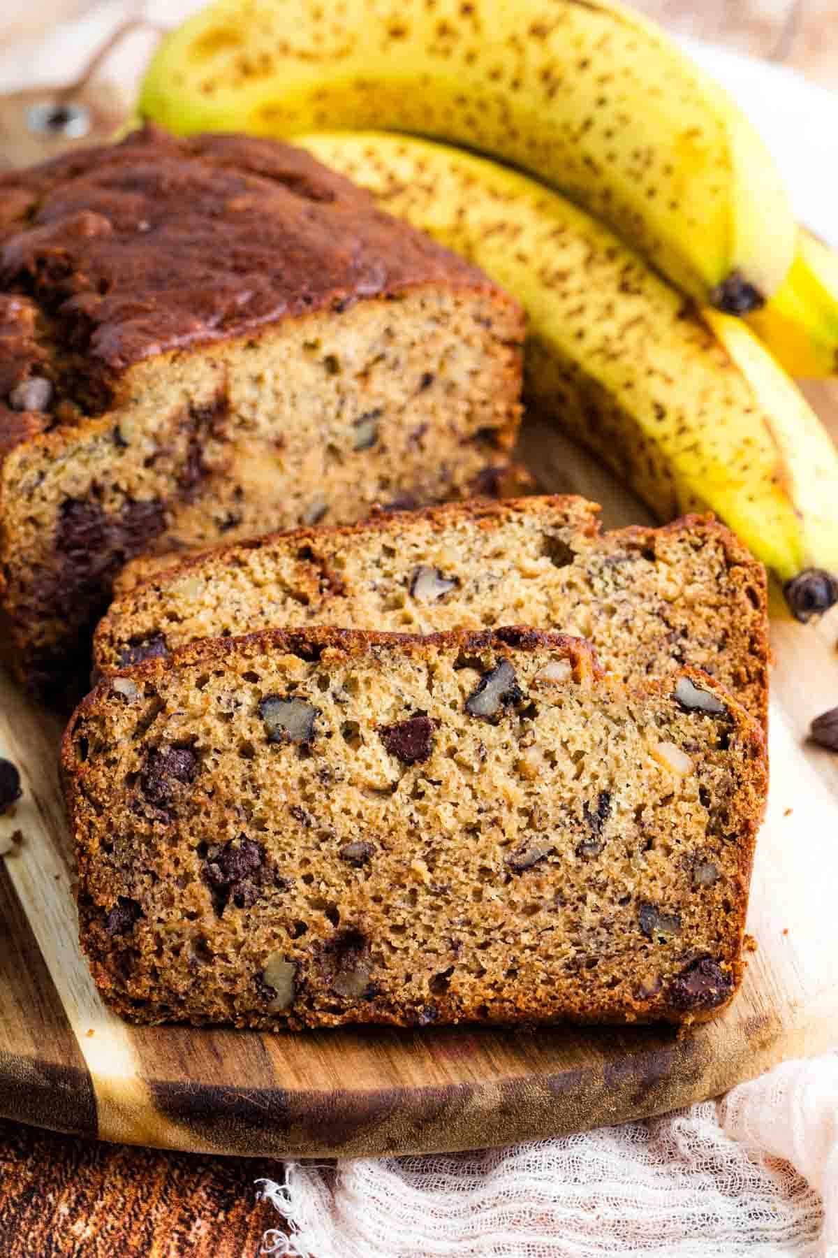 Two slices of gluten free chocolate chip banana bread in front of the loaf