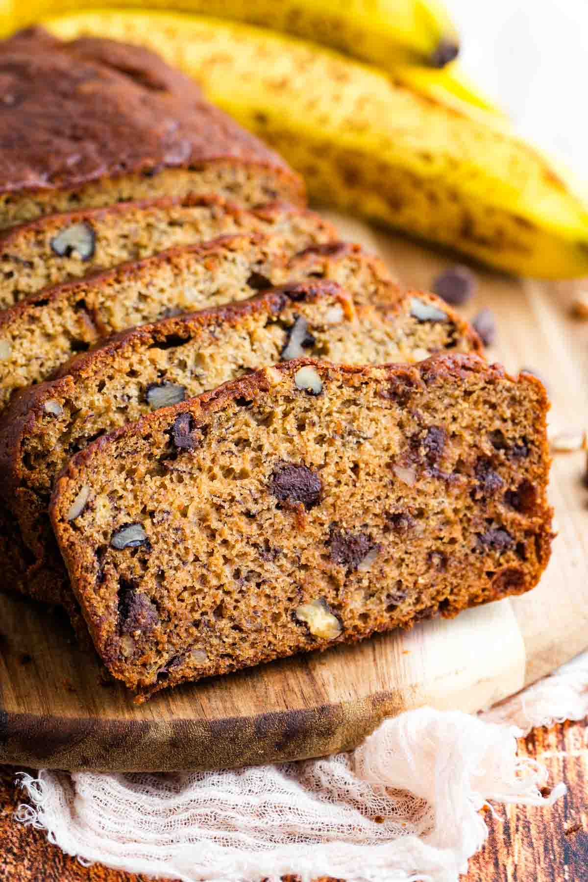 Slices of gluten free chocolate chip banana bread leaning against the loaf