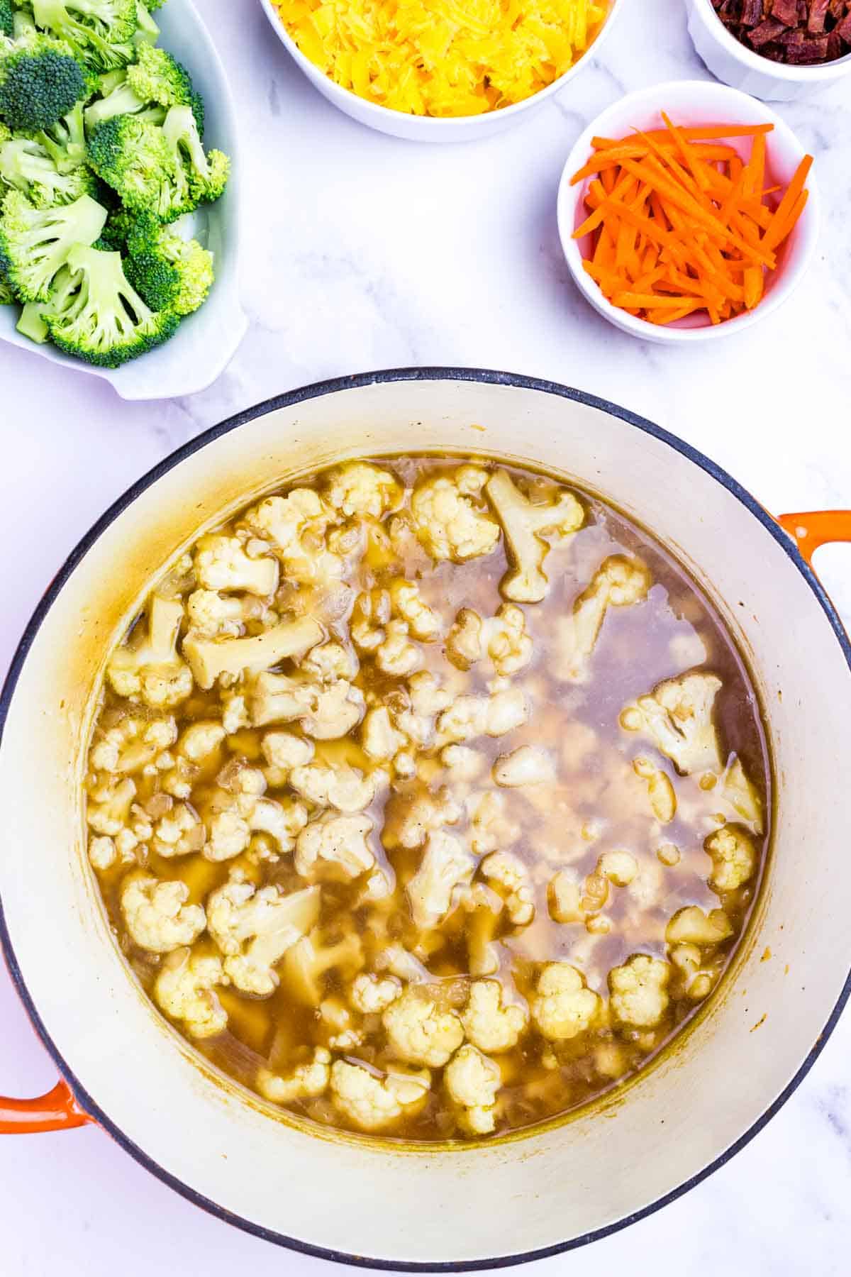 Cauliflower florets summering in broth.