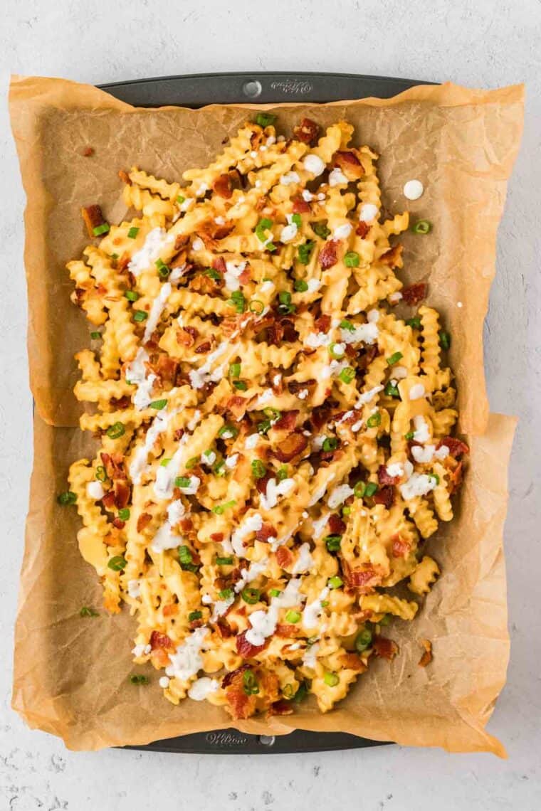 Fries topped with cheese sauce, bacon, ranch, and green onions