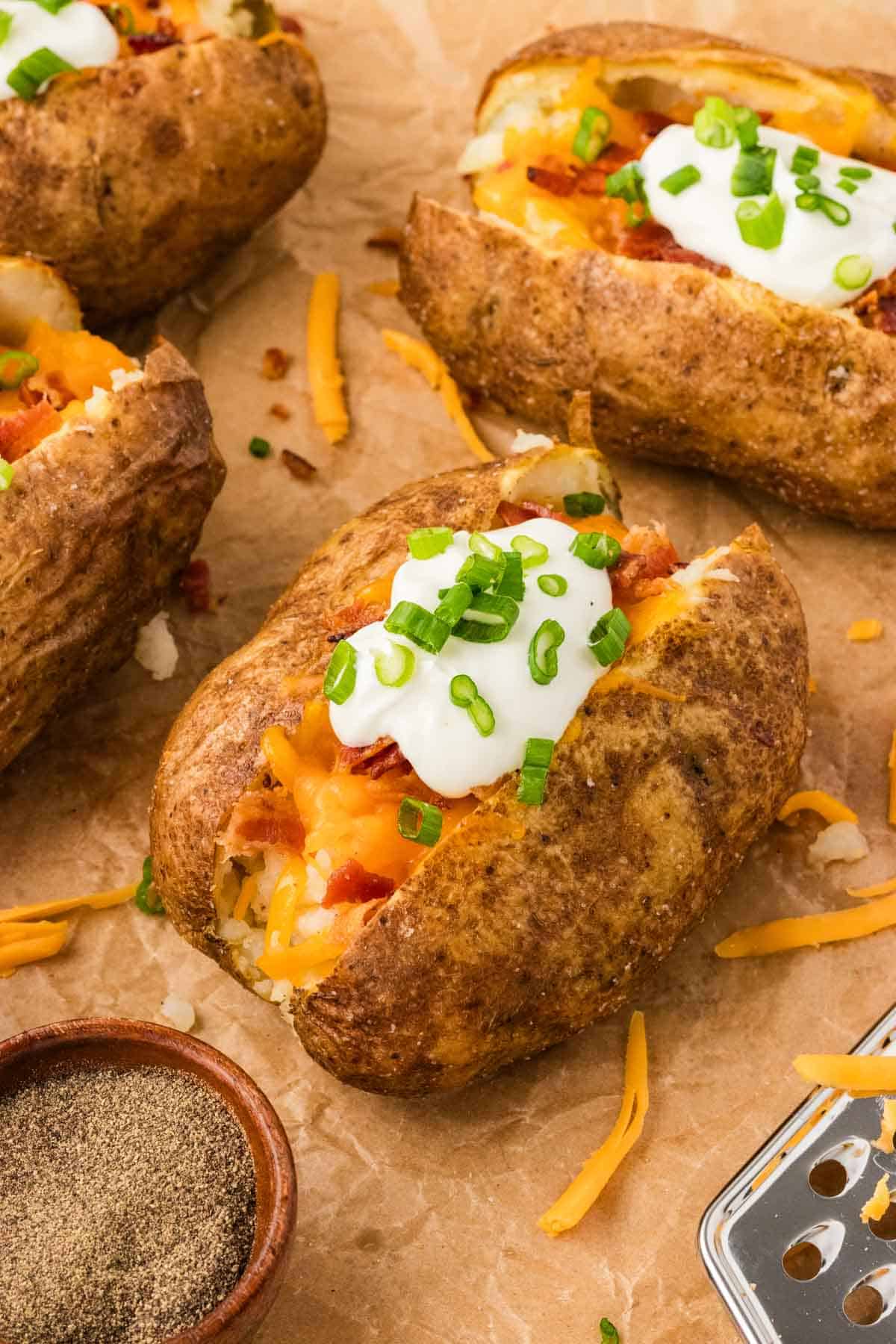 A loaded baked potato on parchment paper