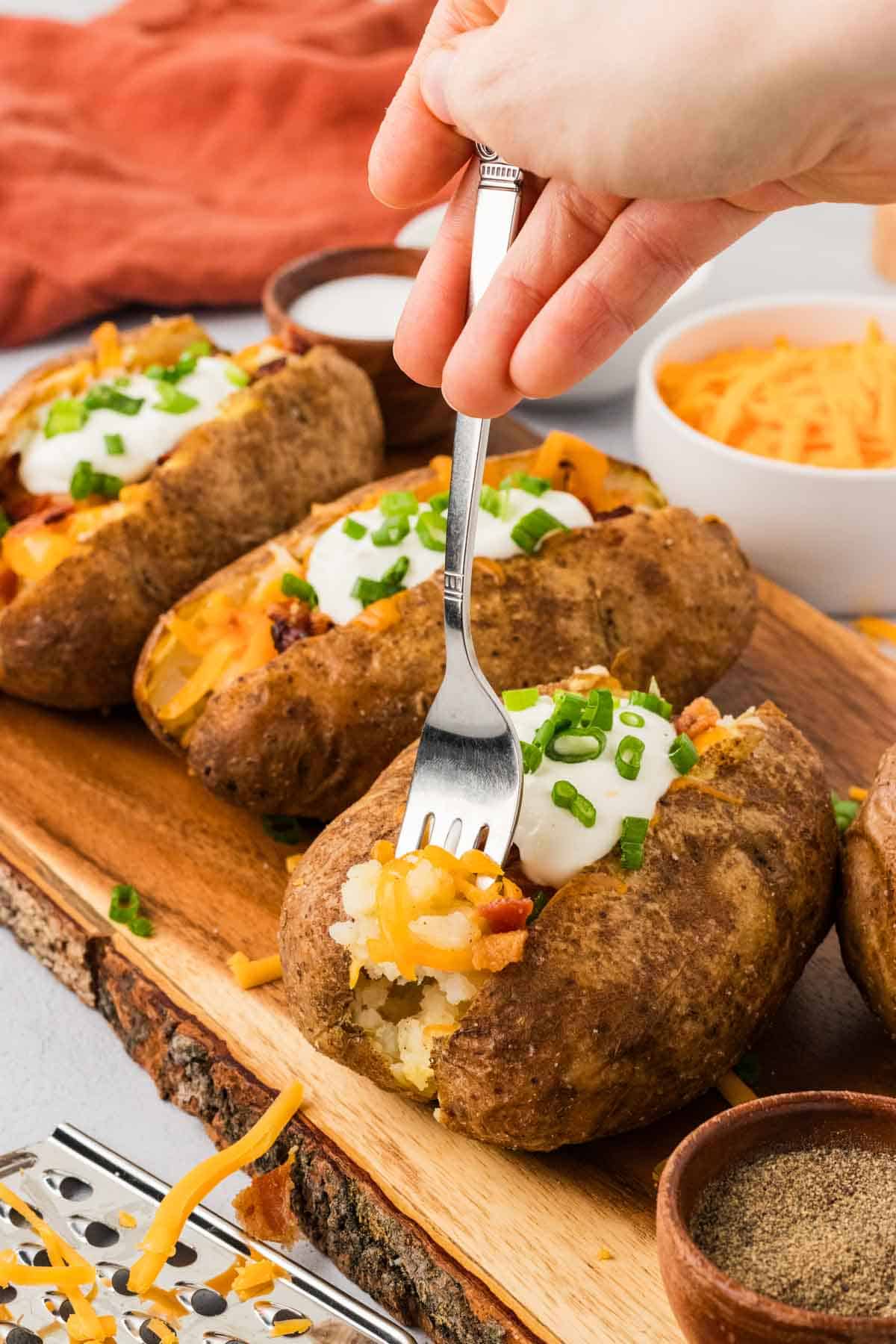 A fork in a loaded baked potato
