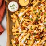 Overhead view of a baking sheet of loaded french fries
