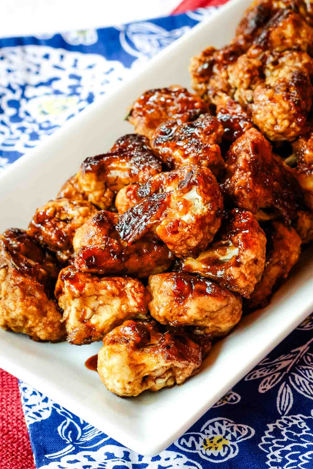 Balsamic glazed cauliflower wings on a white rectangular plate.