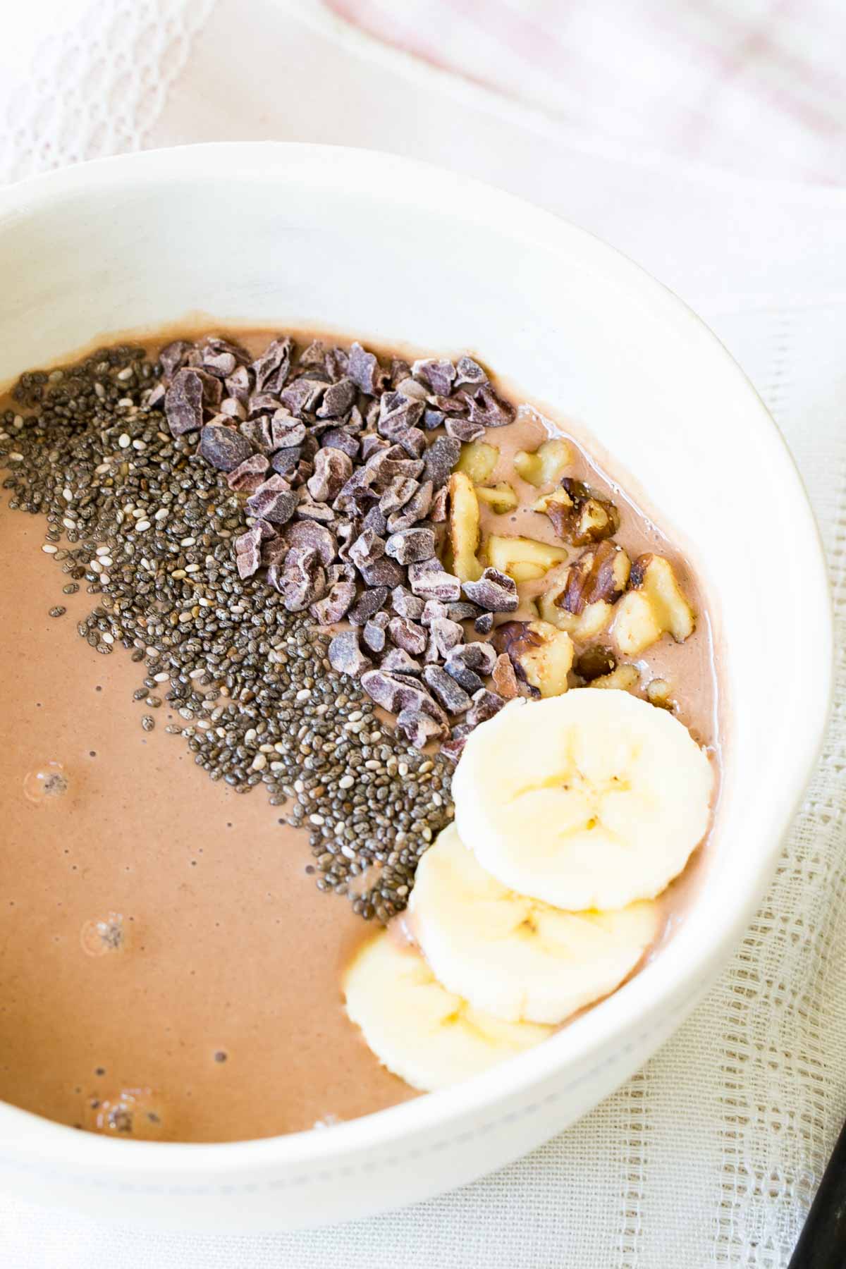 A chocolate banana smoothie bowl with toppings.