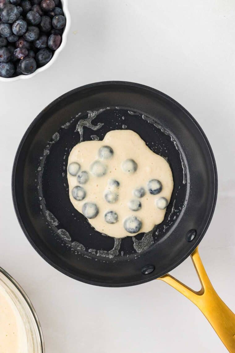 Blueberry pancake batter in a skillet