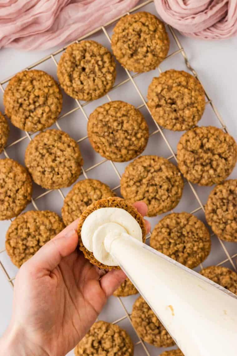 Piping cream filling onto an oatmeal cokie