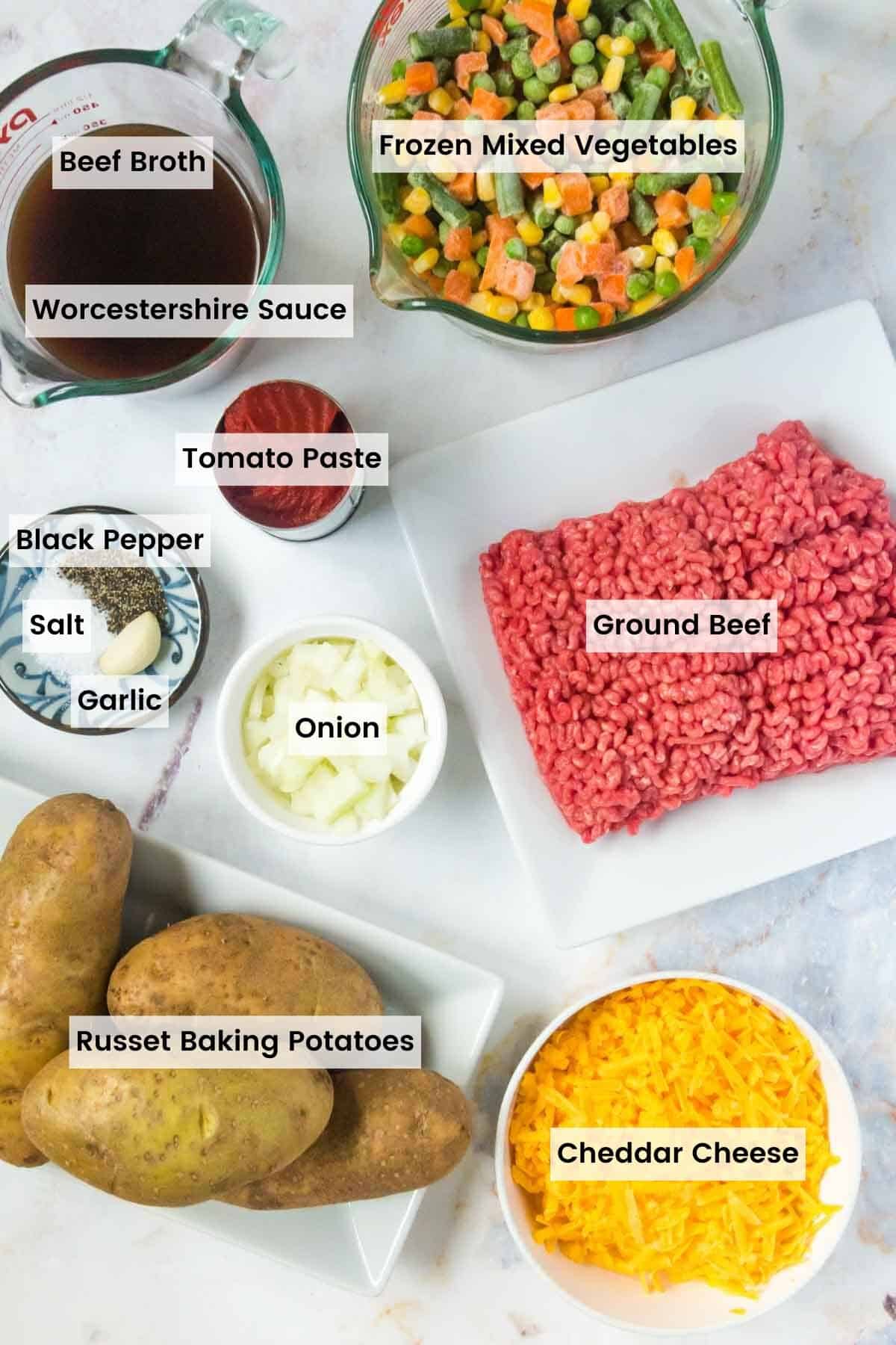 Bowls and plates of ingredients to make cottage pie baked potatoes with text labels.
