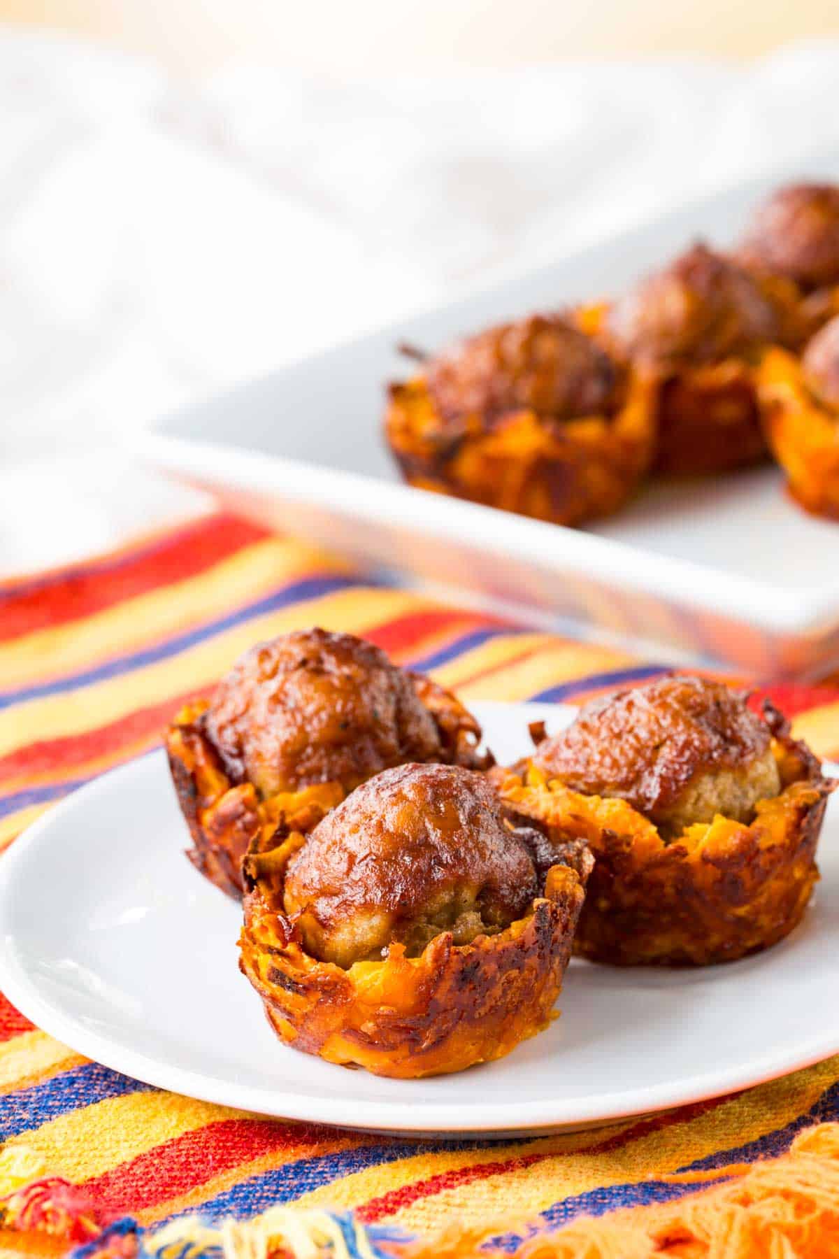 Three barbecue meatball sweet potato bites on a plate.