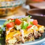 A slice of crustless quiche filled with ground beef with burger toppings on top with text overlay that says "Bacon Cheeseburger Crustless Quiche".