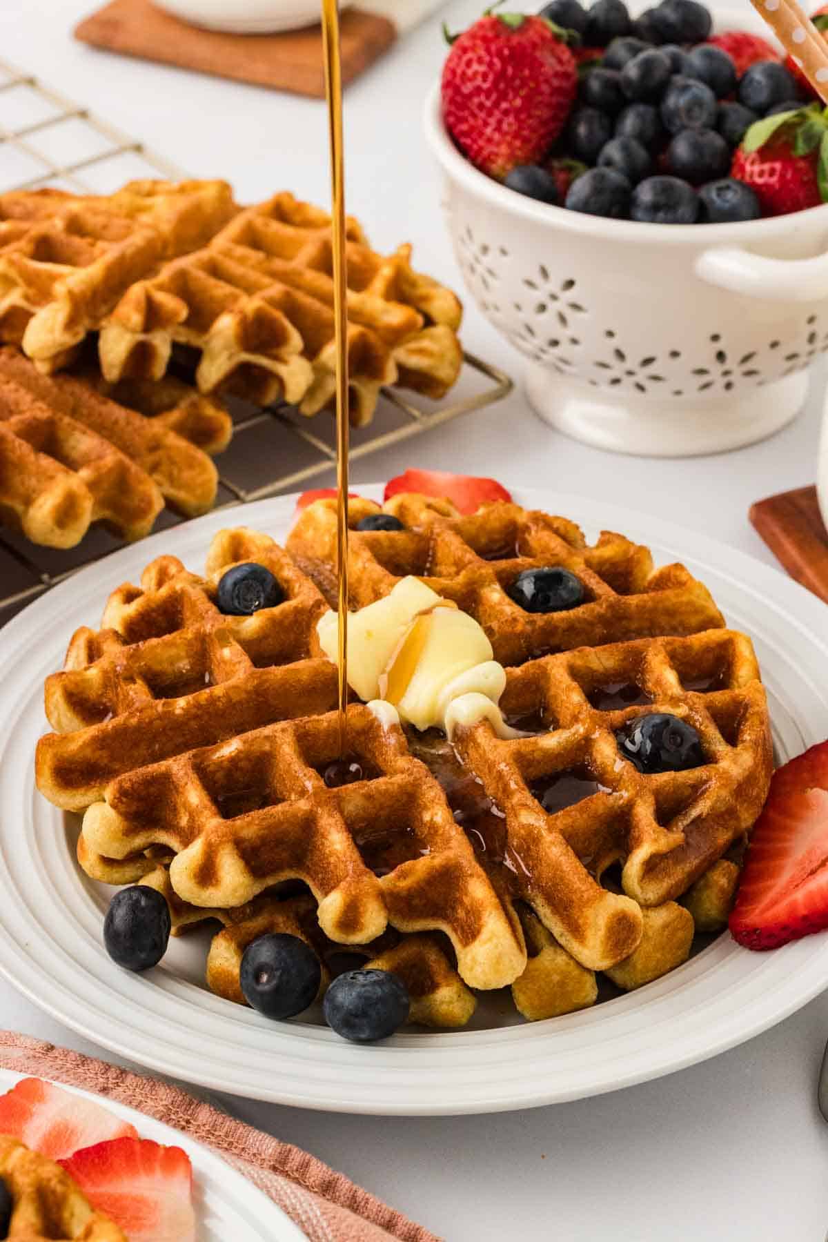 Syrup being drizzled over gluten free buttermilk waffles