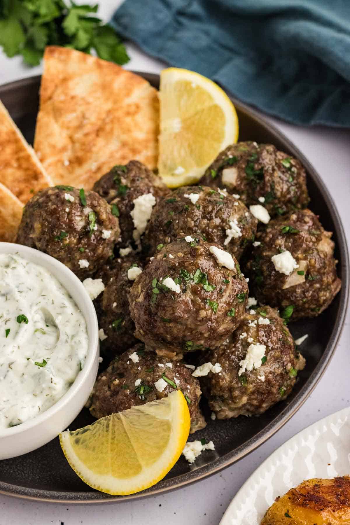 A plate of Greek meatballs with tzatziki and pita