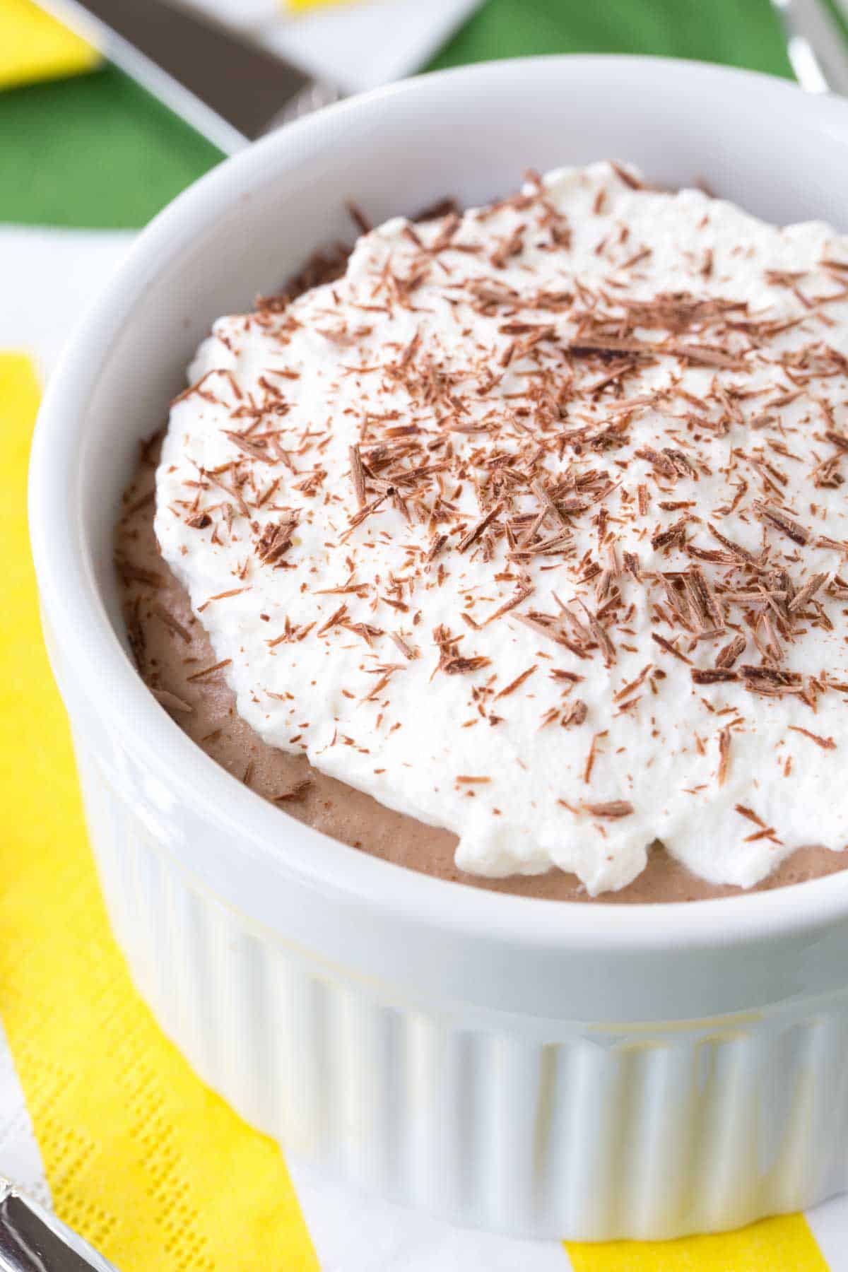 A close-up of whipped cream on top of a mini cream pie in a ramekin.