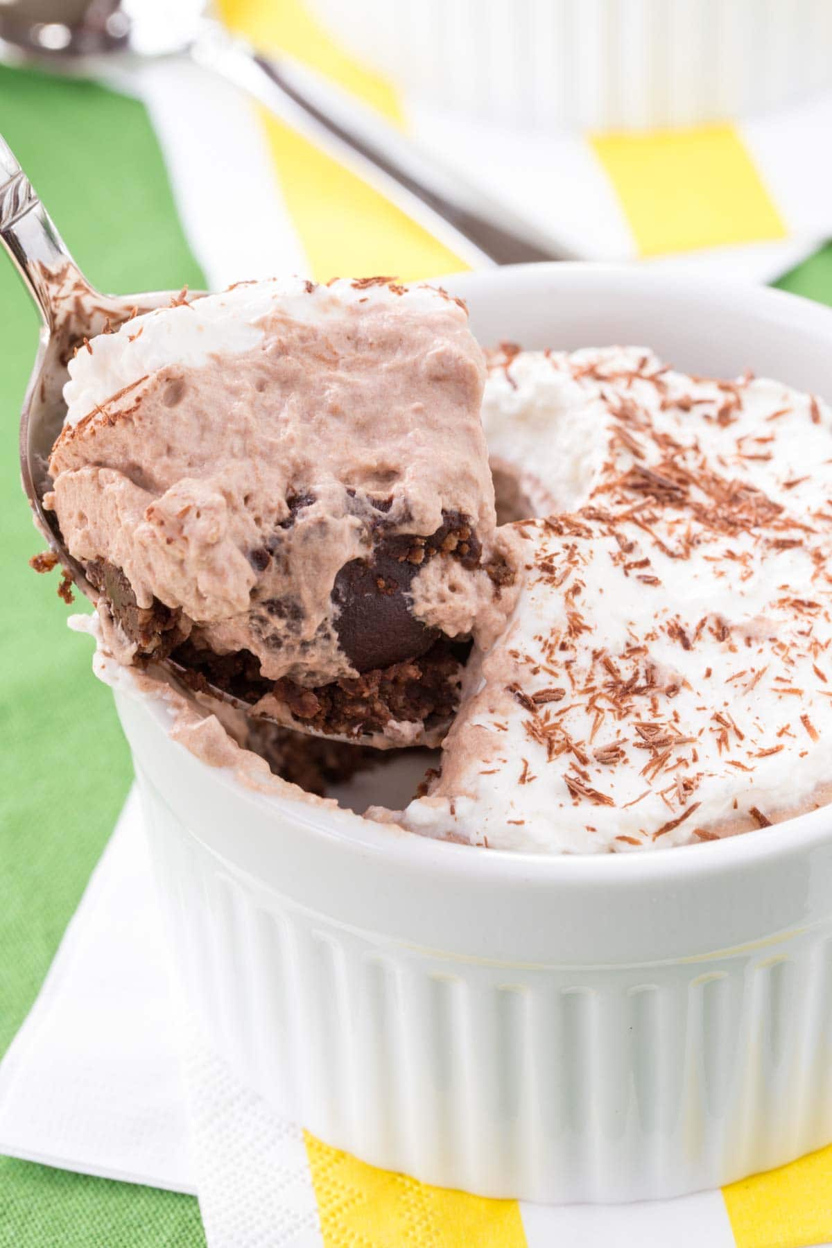 A spoonful of Bailey's chocolate mousse on the edge of a ramekin of a mini pie.