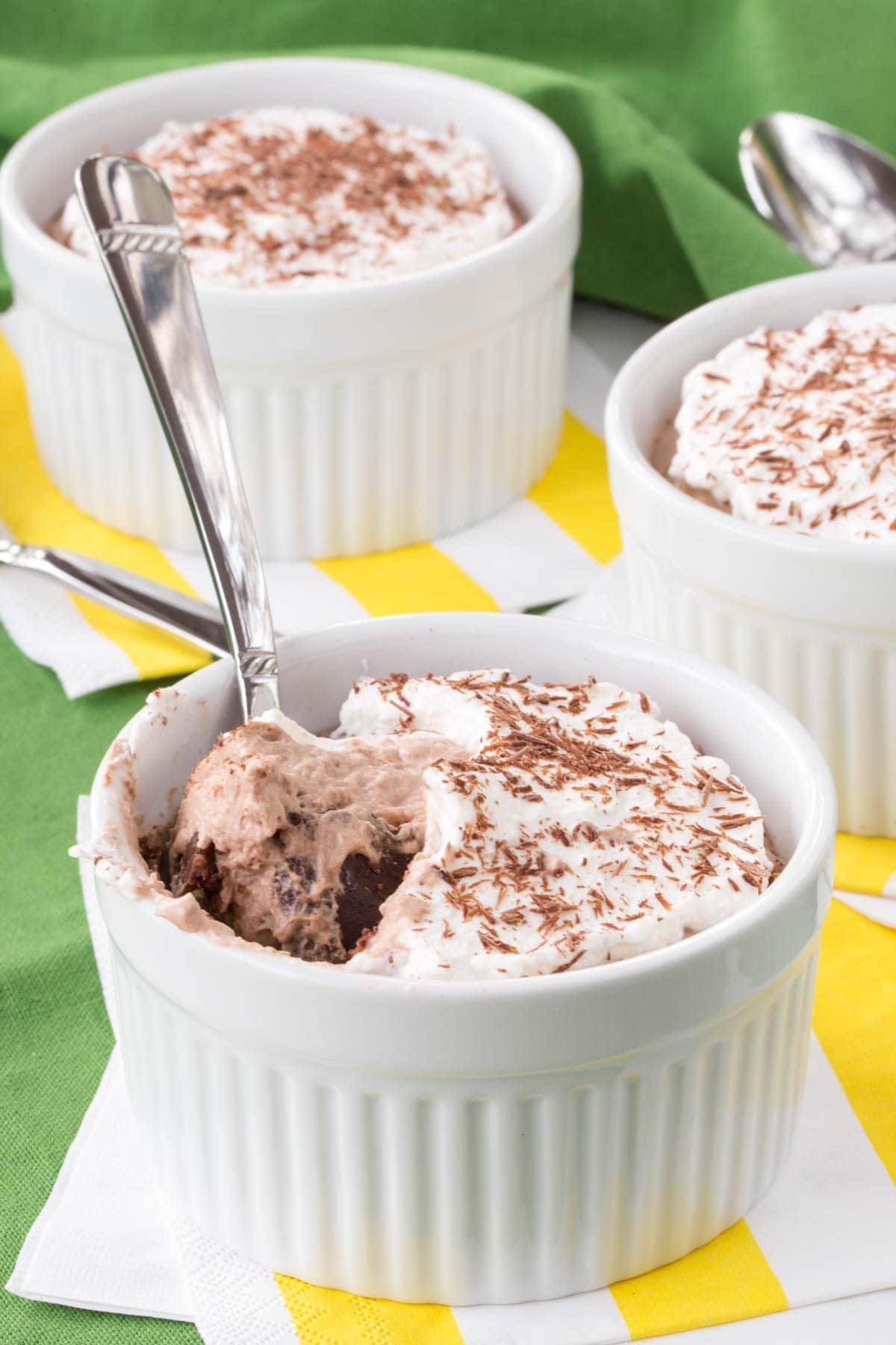 A spoon scooping Irish cream mousse and fudge out of a ramekin.