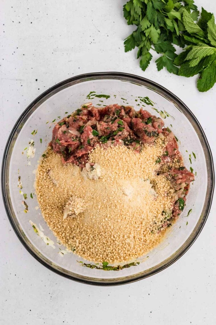 Breadcrumbs added to the ground beef and herb mixture.