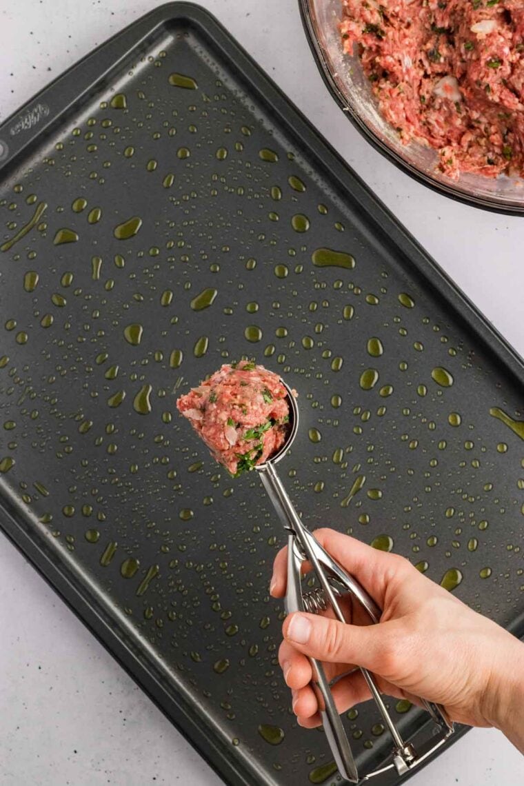 A cookie scoop with meatball dough