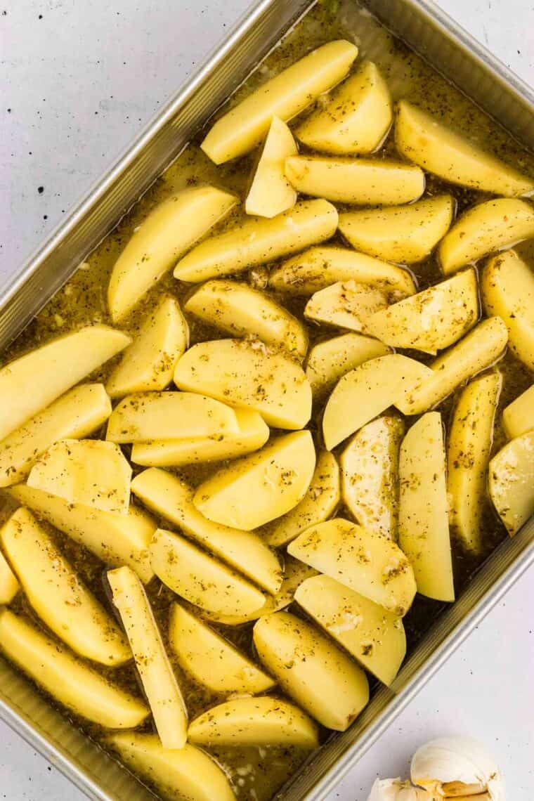 Potatoes are baked in a lemony, garlicky broth until golden on the outside and soft on the inside in this Greek Potatoes recipe. The lemon broth poured over the potato wedges in the baking dish