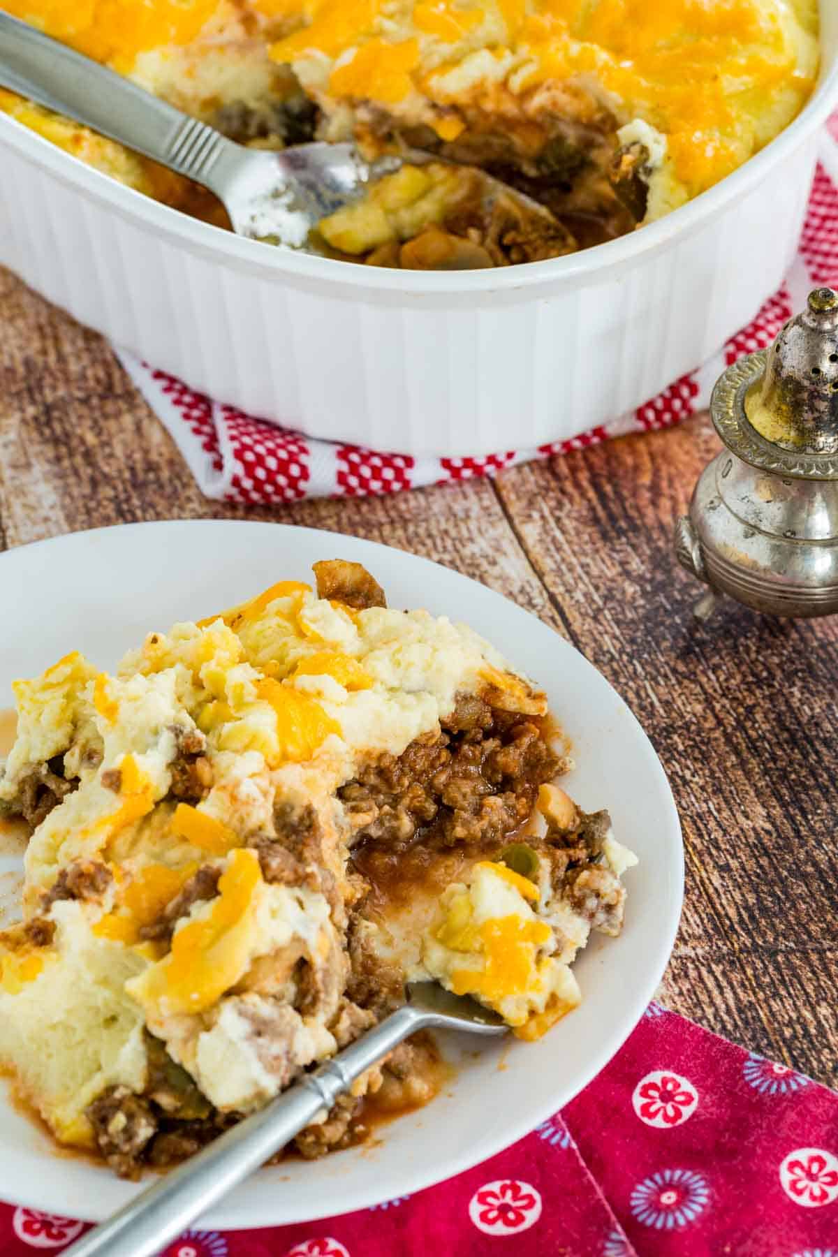 A serving of the shepherds pie topped with cauliflower mash on a plate with a fork.