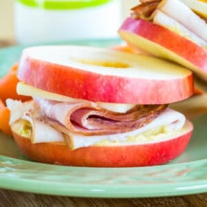 A closeup of an apple sandwich with turkey, ham, and cheese.