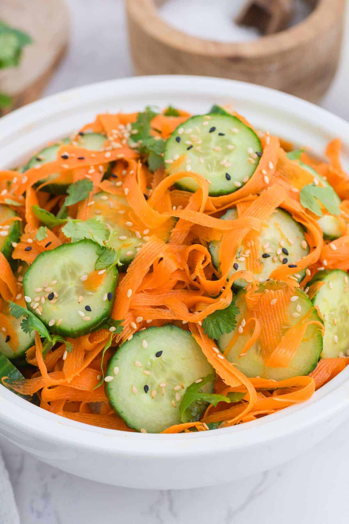 A white bowl of Asian carrot cucumber salad