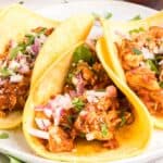 Close front view of chicken tinga tacos on a plate