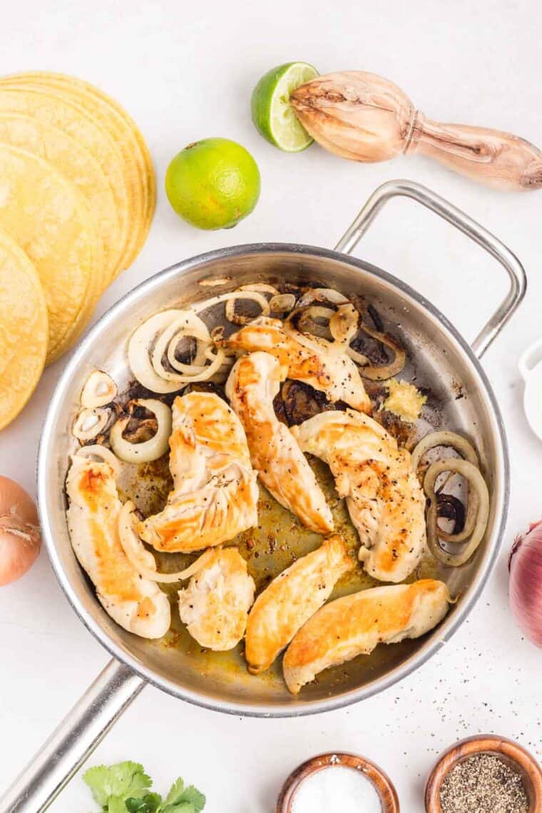 Cooking chicken and onions in a frying pan