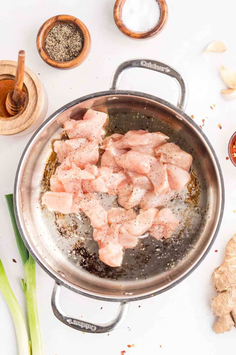 This easy sweet and spicy chicken is full of flavor, with honey, brown sugar, and sriracha. Ready in just 20 minutes! Diced chicken in a frying pan