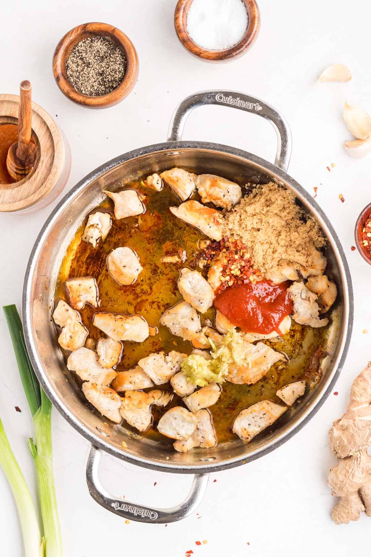 This easy sweet and spicy chicken is full of flavor, with honey, brown sugar, and sriracha. Ready in just 20 minutes! Honey, brown sugar, sriracha, and seasonings added to diced chicken in a pan