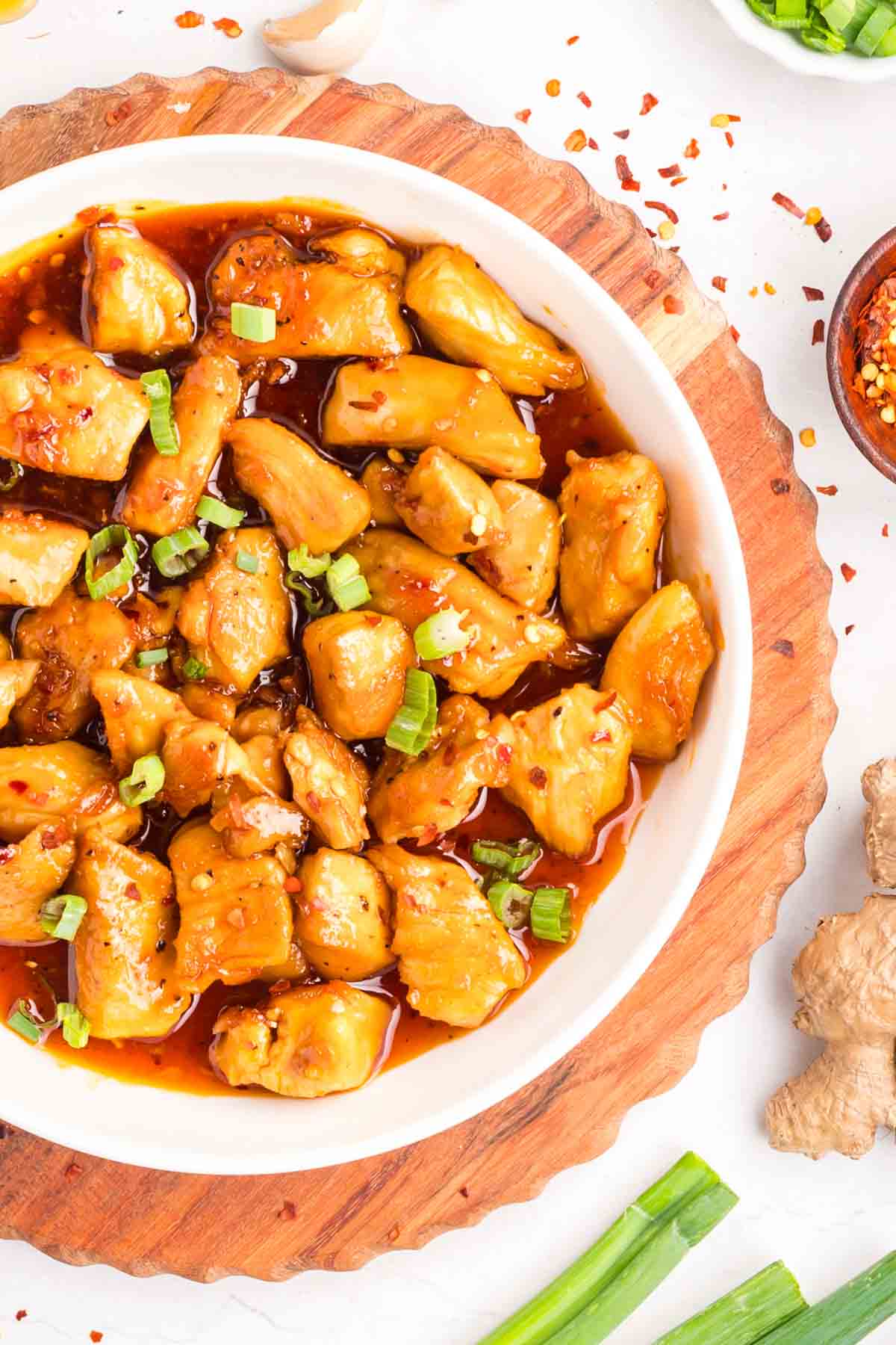 This easy sweet and spicy chicken is full of flavor, with honey, brown sugar, and sriracha. Ready in just 20 minutes! Overhead view of sweet and spicy chicken in a white bowl