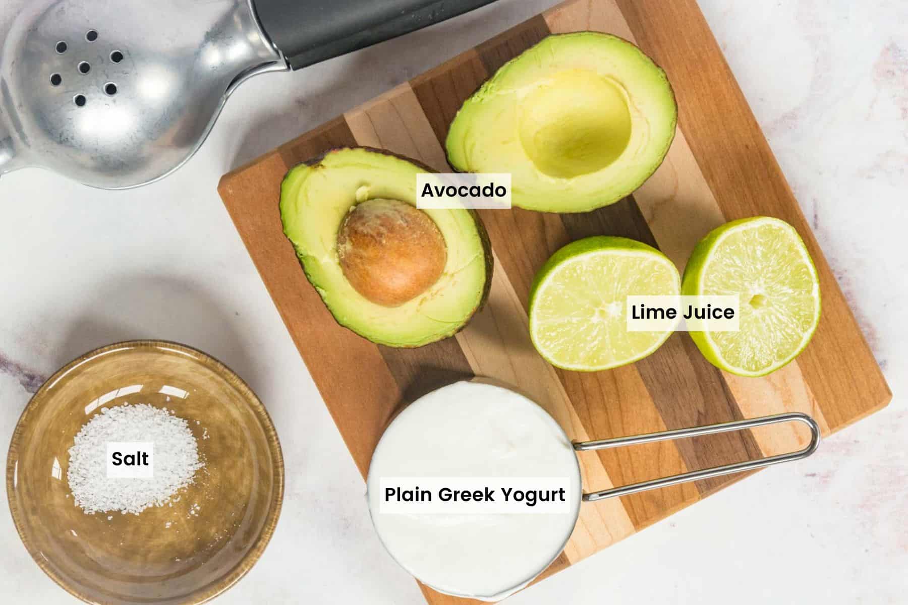 Ingredients to make avocado crema with text labels and a citrus juicer on a table.
