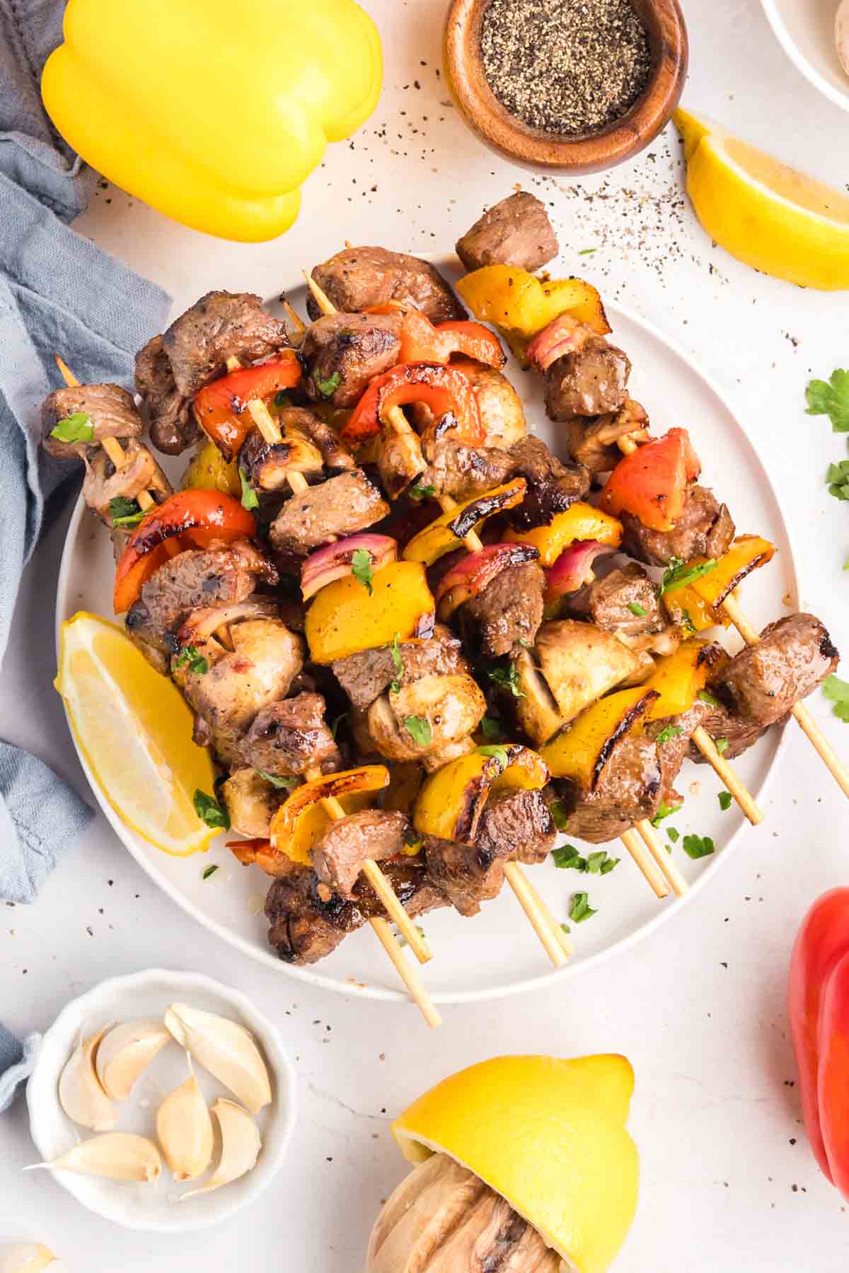 Chunks of sirloin are marinated then threaded onto skewers with onions, bell peppers, and mushrooms to make these beef kebabs. Overhead view of beef kebabs on a plate