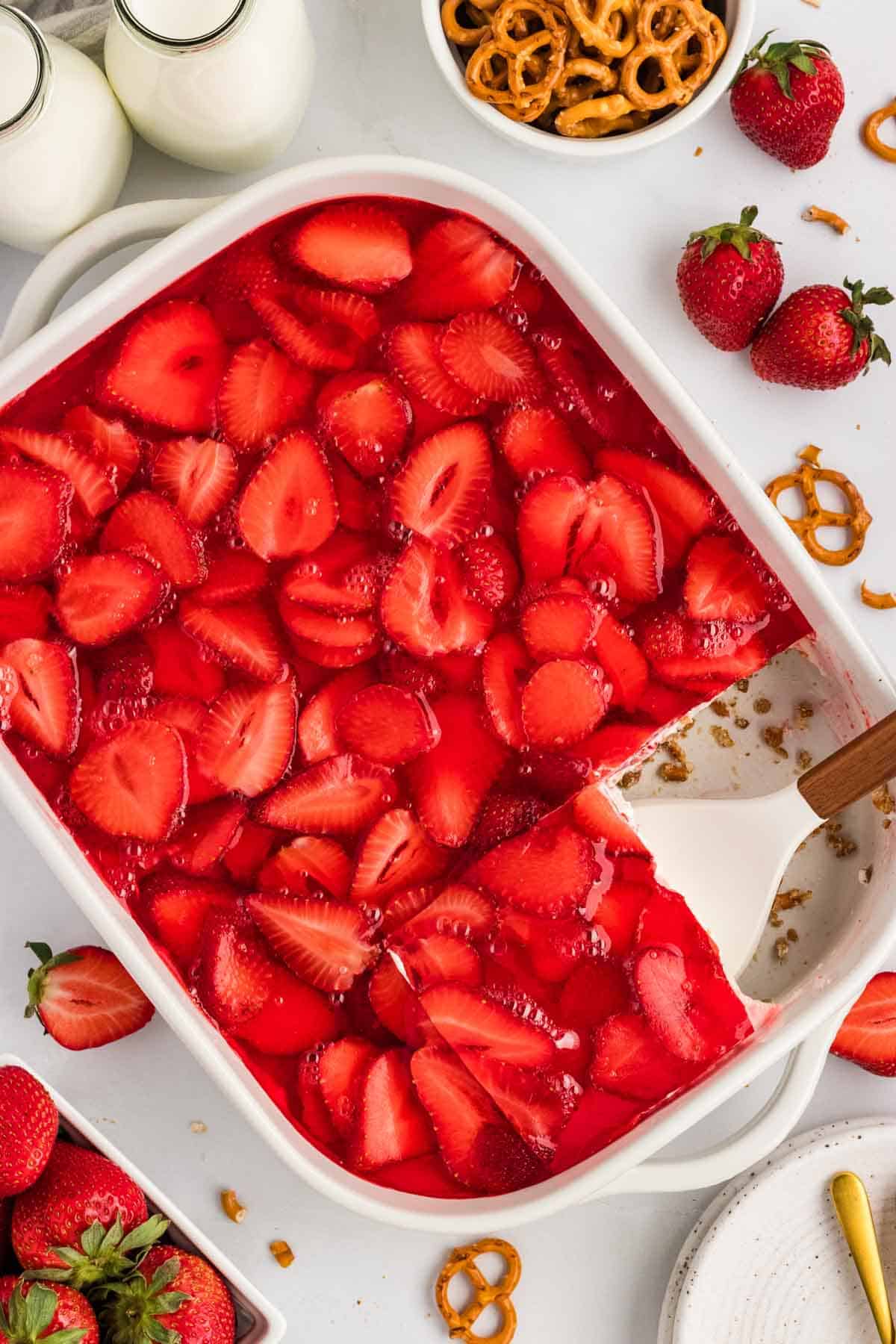 Overhead view of a pan of strawberry pretzel salad with a slice missing