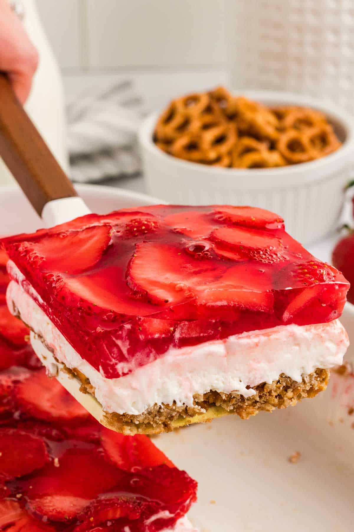 A slice of strawberry pretzel salad on a spatula