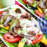 Two plates of grilled steak and mango salad.