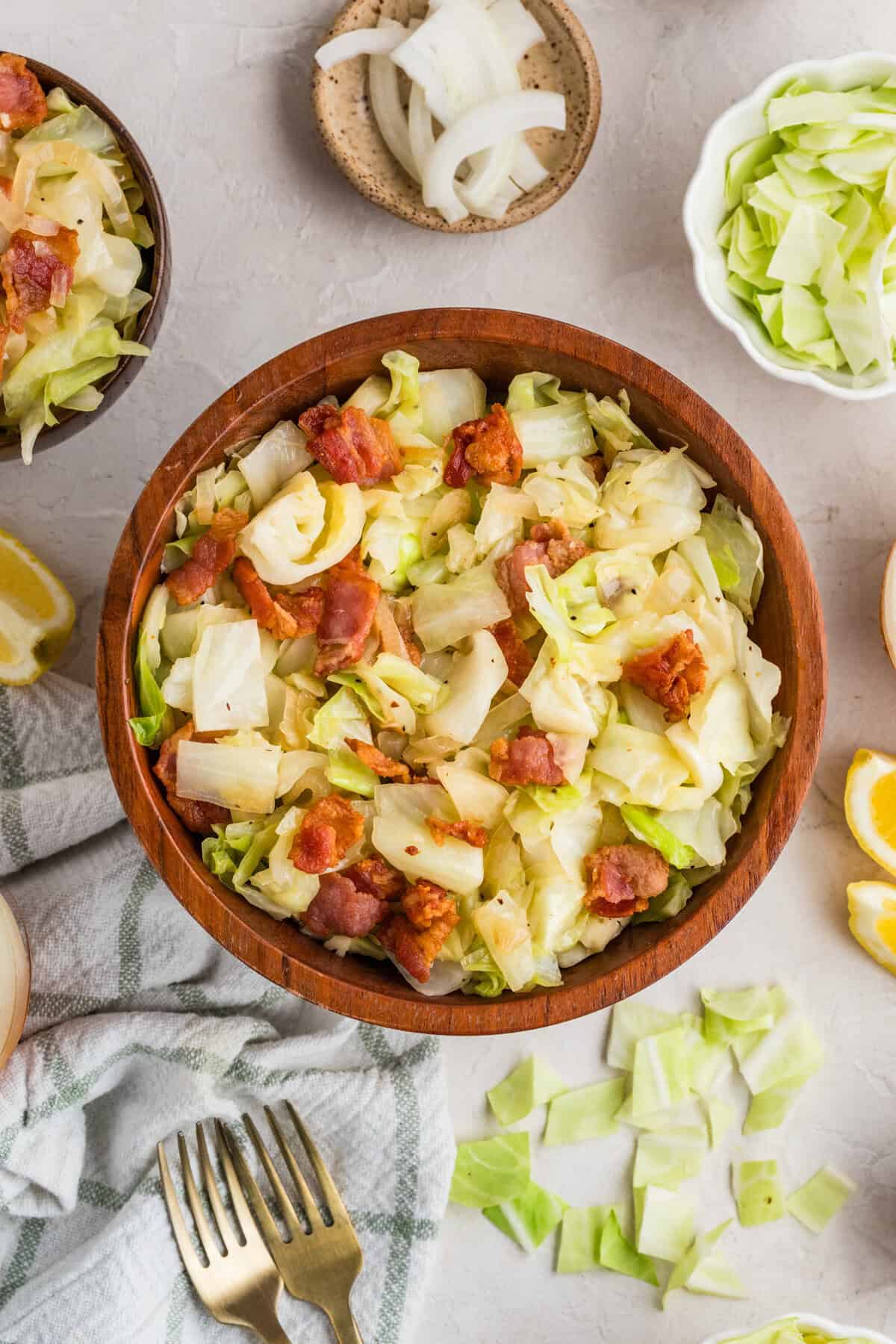 This easy Fried Cabbage recipe turns a handful of ingredients into a savory side dish perfect for busy weeknights & potlucks. Fried cabbage with bacon in a wooden bowl