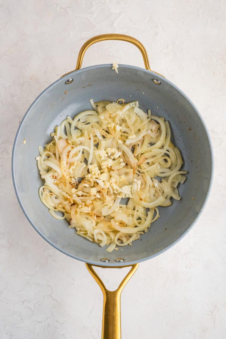 This easy Fried Cabbage recipe turns a handful of ingredients into a savory side dish perfect for busy weeknights & potlucks. Garlic added to cooked onions in a skillet