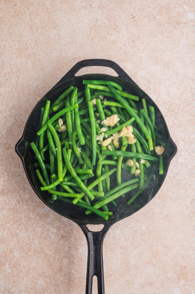 Green beans and sliced garlic in a skillet
