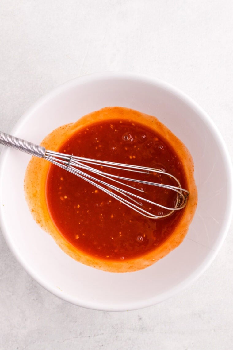 Whisking buffalo marinade ingredients in a bowl