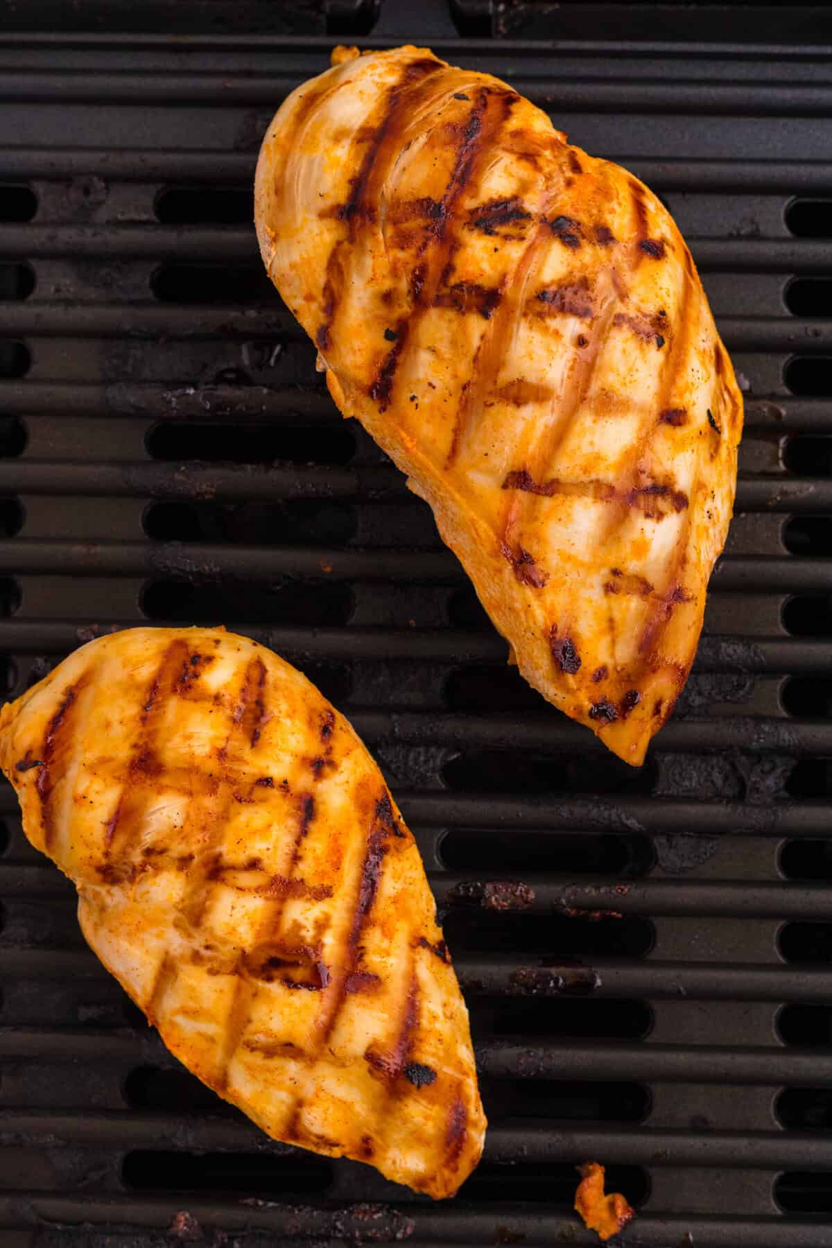 Buffalo chicken breasts cooking on the grill