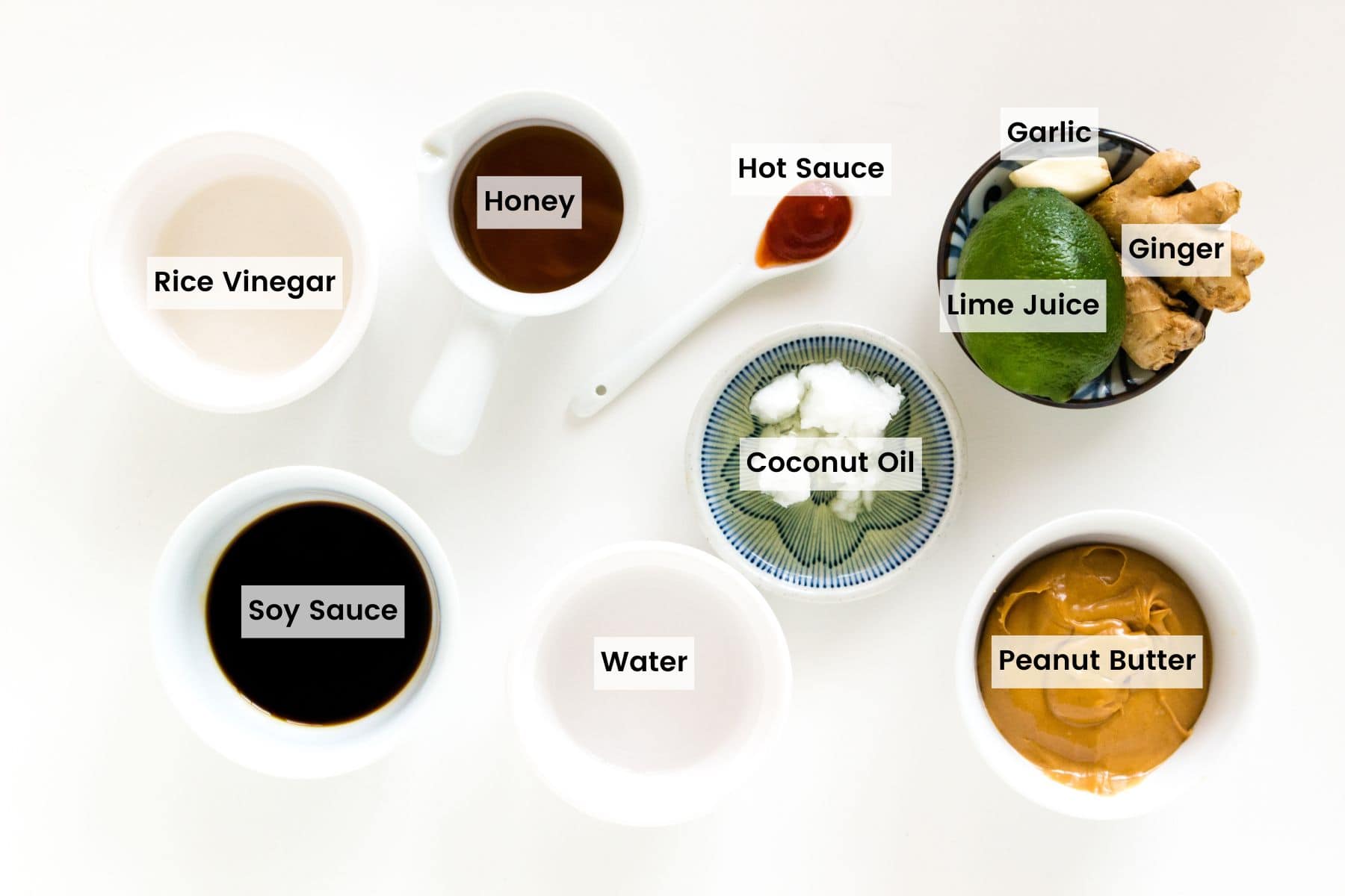 Bowls of ingredients used in making peanut sauce with text labels.