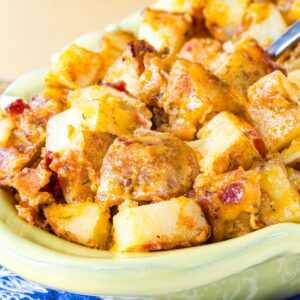 A closeup of cheese bacon ranch potatoes in a yellow dish.
