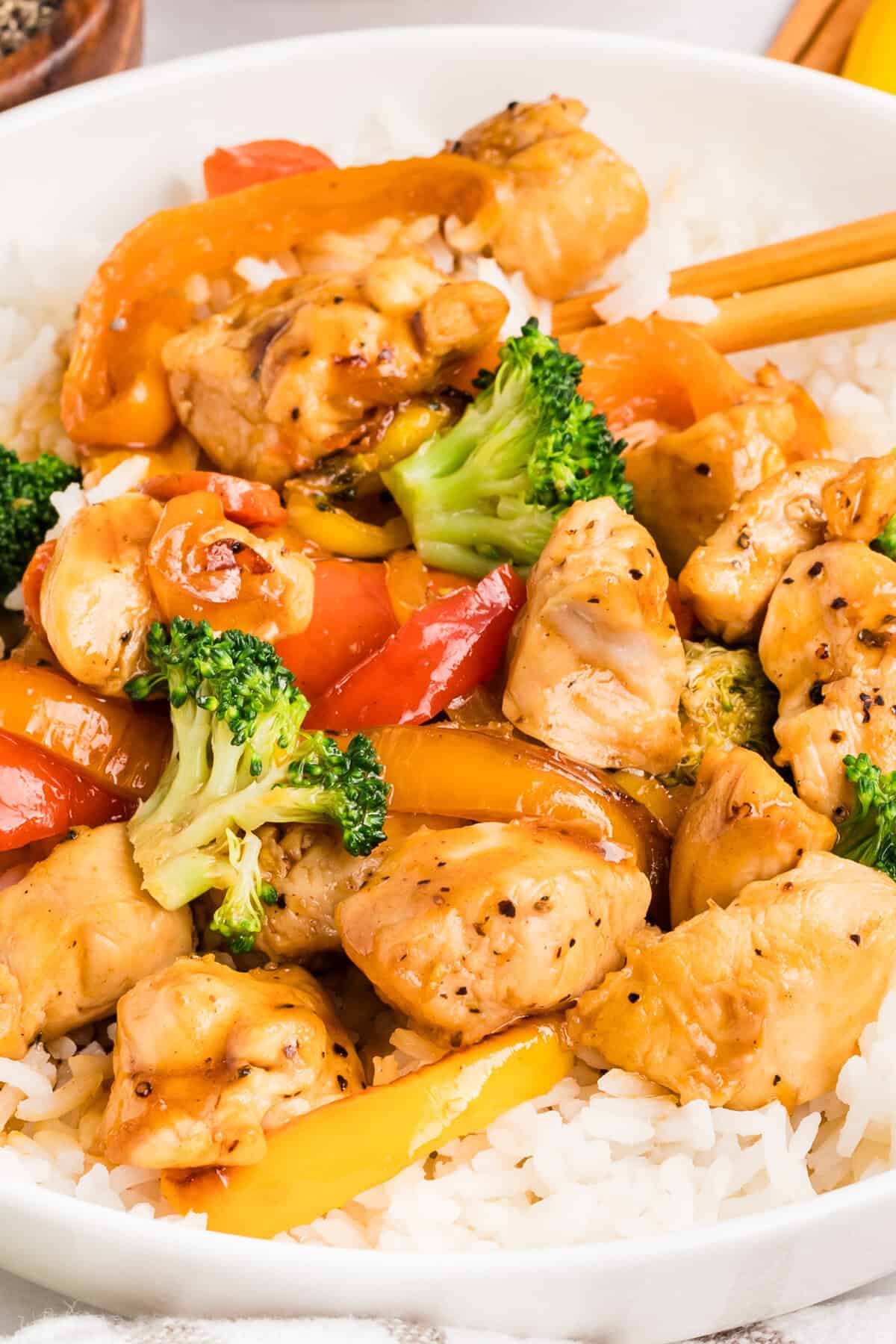 Close up of a plate of chicken and vegetable stir fry over rice