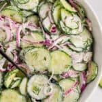 Overhead view of a white bowl of creamy cucumber salad