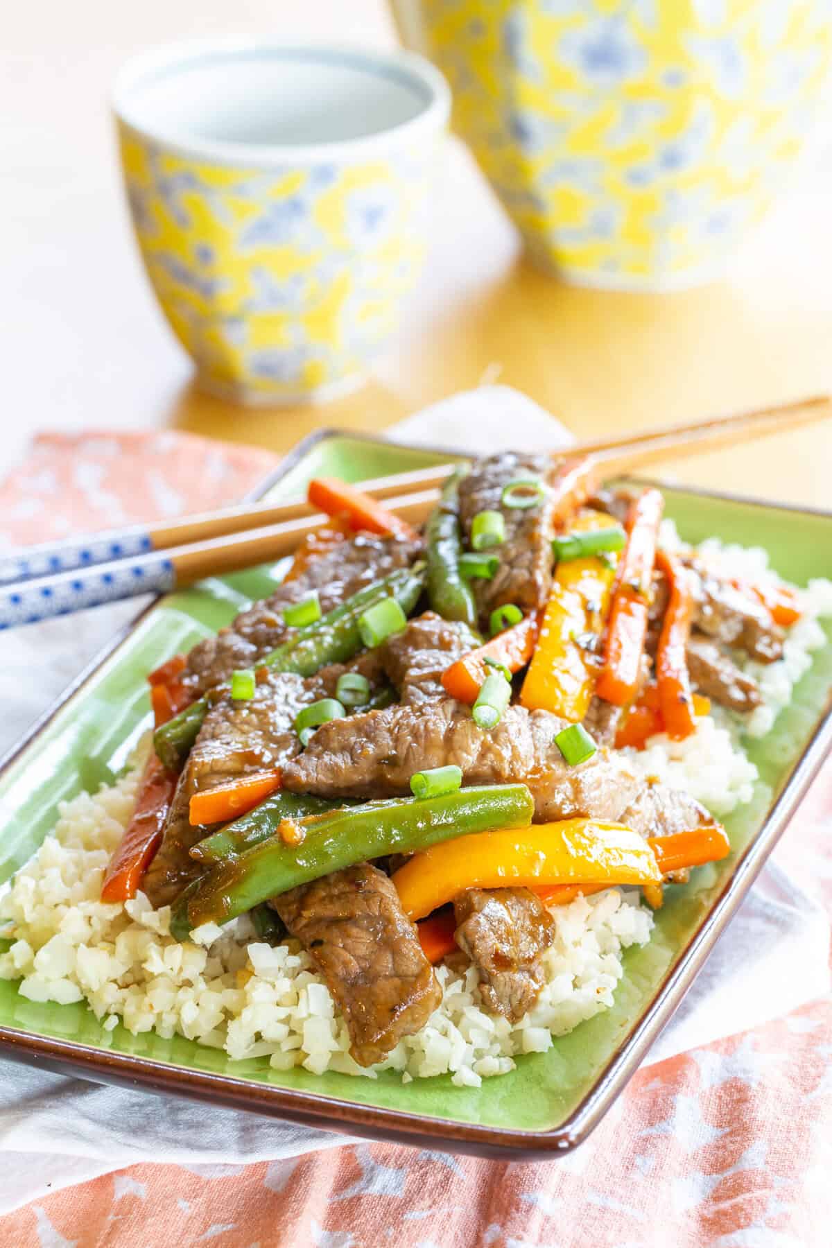 Stir fried beef, carrots, peppers, and green beans on a bed of cauliflower rice.