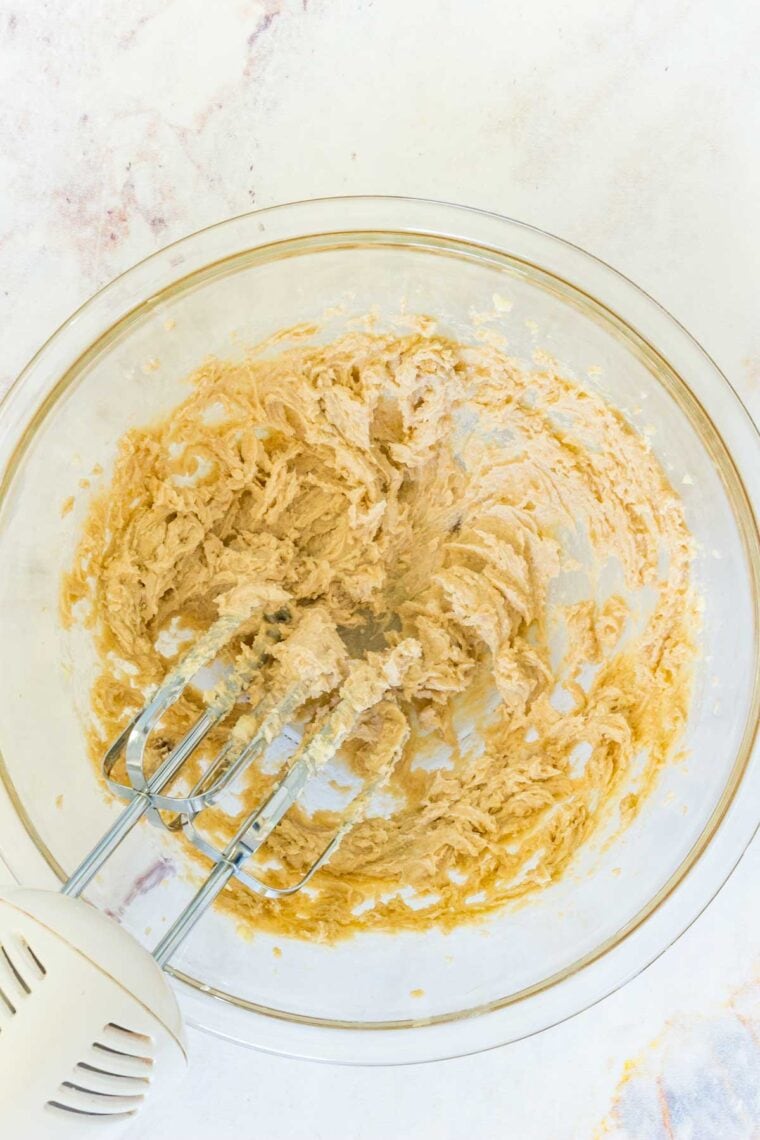 An easy recipe for edible chocolate chip cookie dough that's gluten-free and 100% safe to eat by the spoonful! The perfect sugary treat. Creamed butter and sugar in a bowl with a mixer.