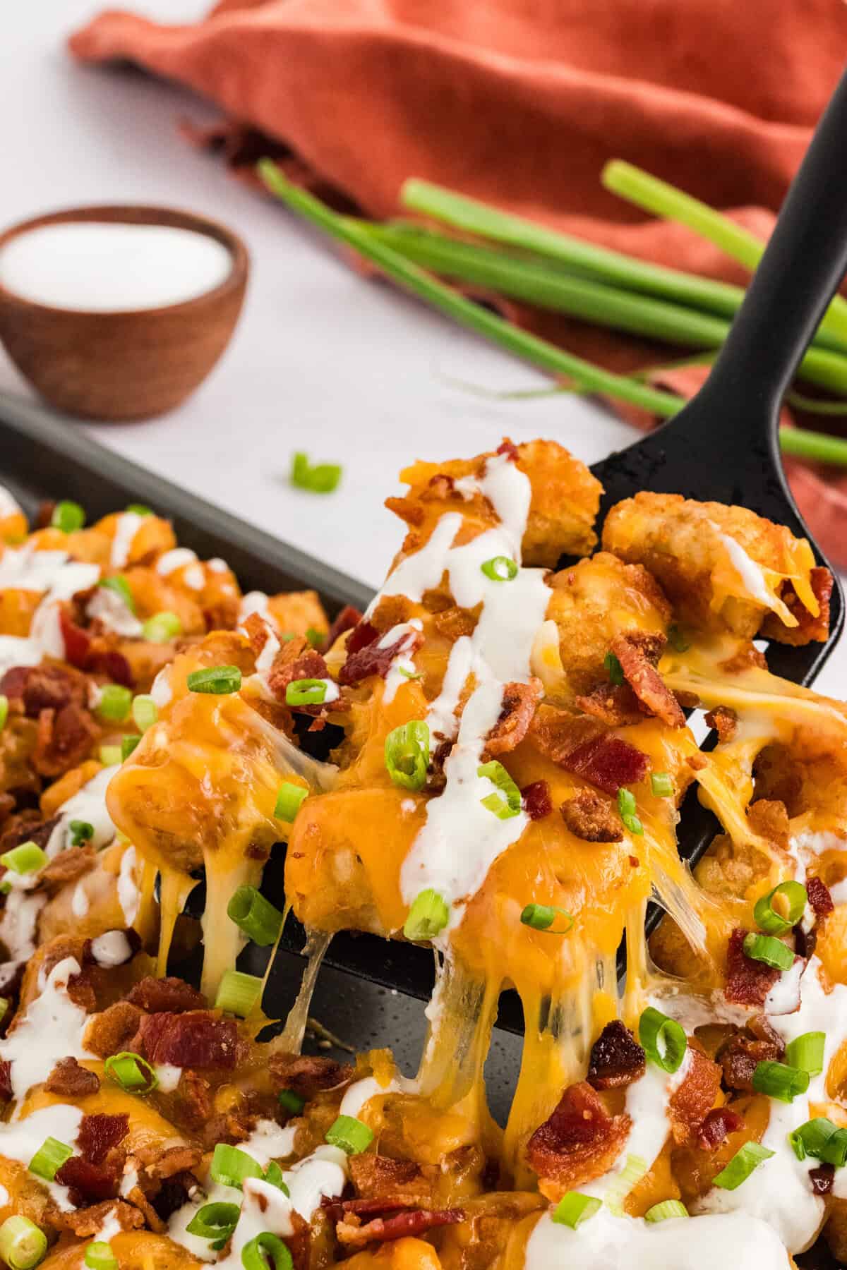 A fork holding a bite of loaded tater tots